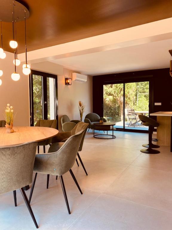 a living room with a table and chairs at Villa La perle des Sylves in Neufchâtel-Hardelot
