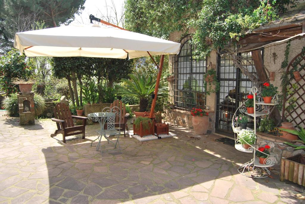 a patio with an umbrella and a table and chairs at Casa Pontecorvi in Velletri