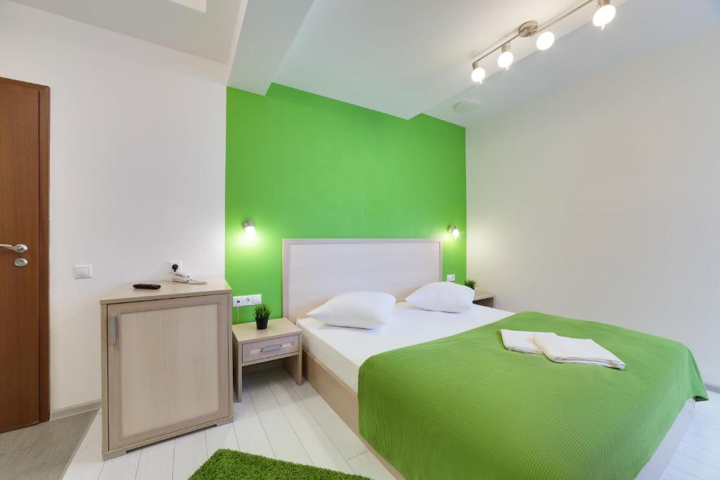 a green and white bedroom with a bed and a mirror at Minima Kuzminki in Moscow