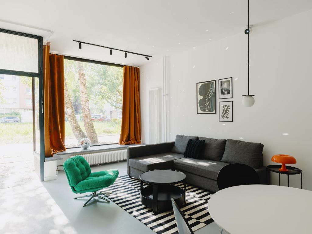 Una sala de estar con un sofá, una mesa y sillas. en NOOK Stay am Checkpoint Charlie, en Berlín