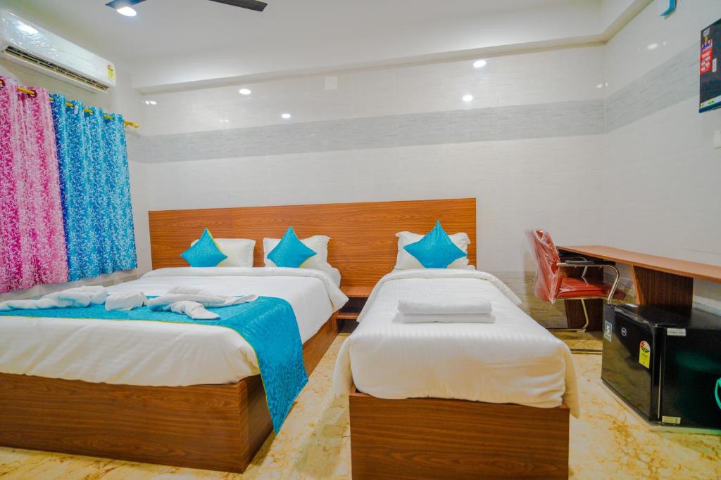 布巴内什瓦尔Hotel Mirka Plaza的一间卧室配有两张单人床和一台电视机