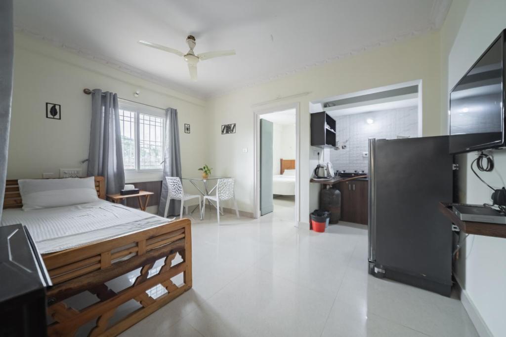 a bedroom with a bed and a living room at Stayhome Suites in Bengaluru