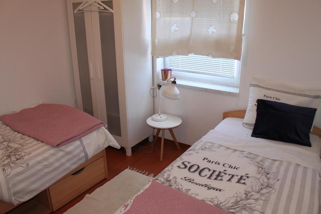 niewielka sypialnia z 2 łóżkami i oknem w obiekcie Vili Apartment Quiet leisure in Preko w mieście Preko