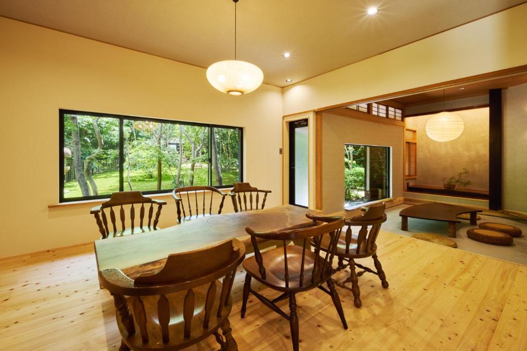 Un comedor y una sala de estar con mesa y sillas. en SHELTER道志 ふらっと高尾山 都心から70分 最大10名 貸切サウナ 雨でもBBQok 焚火花火, en Sagamihara