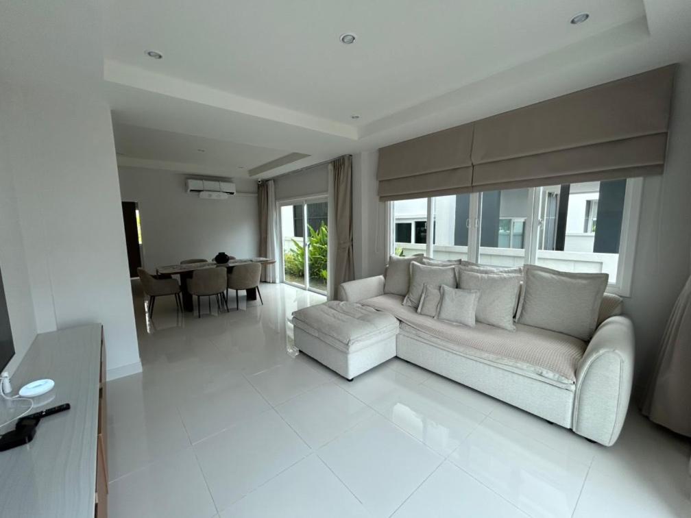 a white living room with a couch and a table at Supalai Rent BANG TAO PHUKET in Phuket