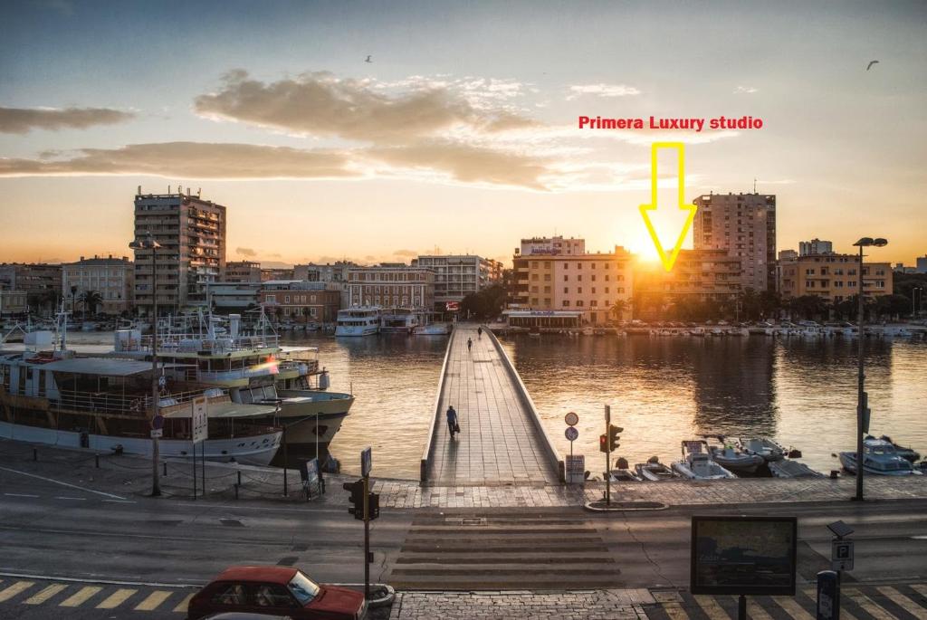 een zonsondergang boven een haven met boten in het water bij Primera Luxury Studio in Zadar