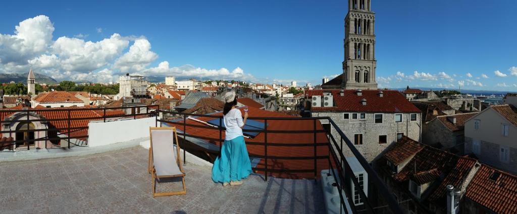 una donna in piedi su un balcone con vista sulla città di Banica Apartments & Rooms a Spalato (Split)