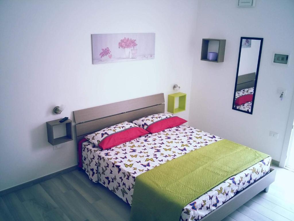 una camera con un letto con due cuscini rossi di Casa Vacanza Carmine a Torre Lapillo