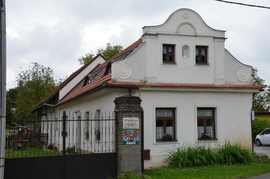 ein weißes Haus mit einem Zaun davor in der Unterkunft Ubytování Hrusice in Hrusice