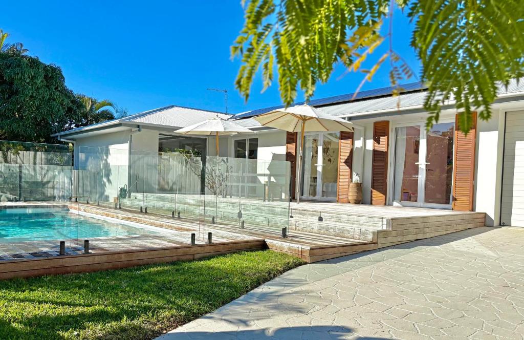 a home with a swimming pool and a house at Modern Coastal Escape - Stylish 3 BR Home with Pool in Byron Bay