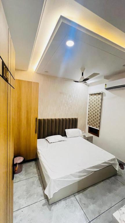 a bedroom with a large white bed and a ceiling at 7th Heaven Hotel in Hisār