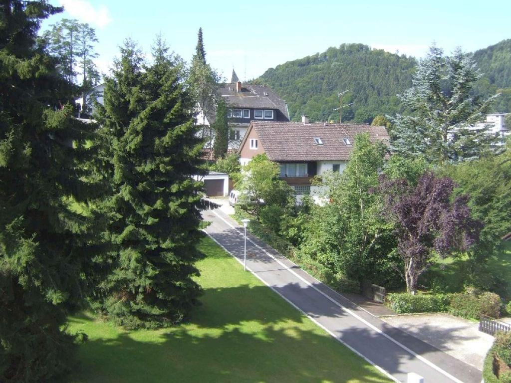 Blick auf einen Garten mit Bäumen und ein Haus in der Unterkunft Ferienwohnung Dunleavy in Bad Herrenalb