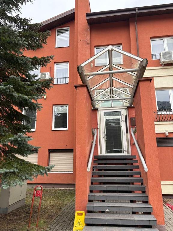 a staircase leading up to a building with a red building at Saulutė in Birštonas