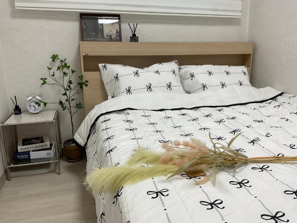 a bedroom with a bed with black and white comforter at Station House Daechi in Seoul