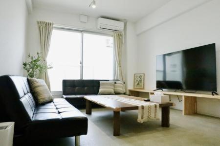 a living room with a couch and a coffee table at Bliss長浜 in Oita