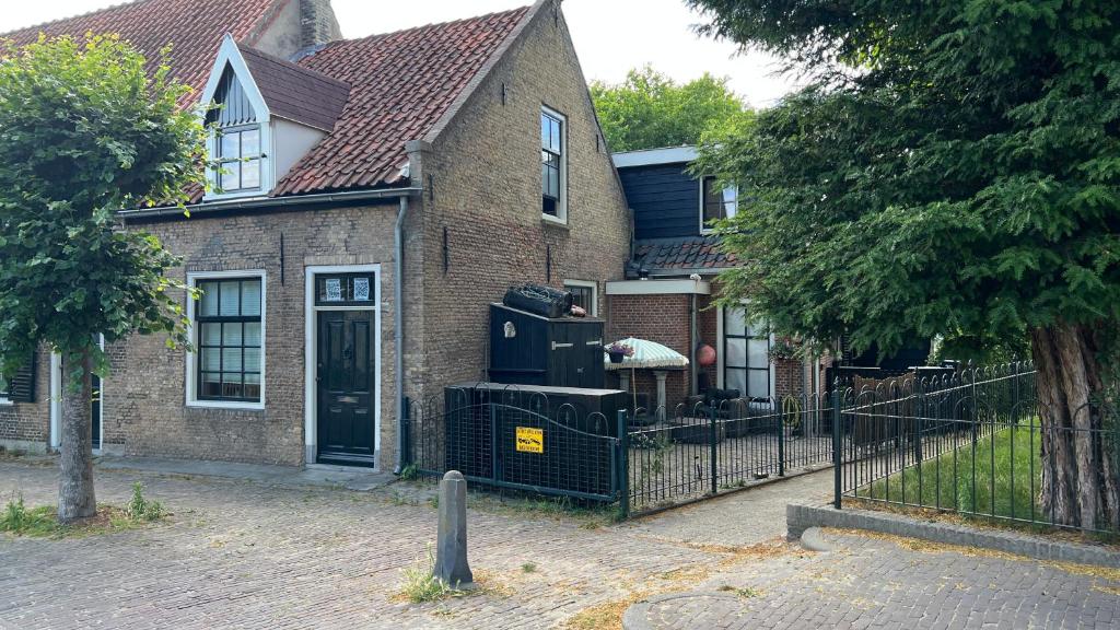 a brick house with a grill in front of it at Vakantiehuis Toxopeus in Burgh Haamstede