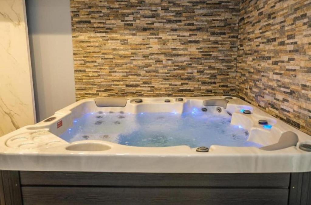 a jacuzzi tub in a room with a brick wall at Kopaonik-President kop apartment 101 free wellness&spa in Kopaonik