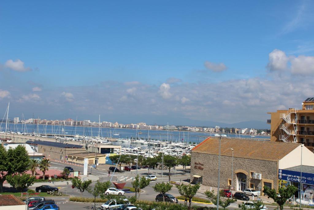 een stad met een jachthaven en een haven met boten bij ROC MAR 3 3B - Apartamento cerca del centro y de la playa - terraza con vistas al mar y al puerto in Roses