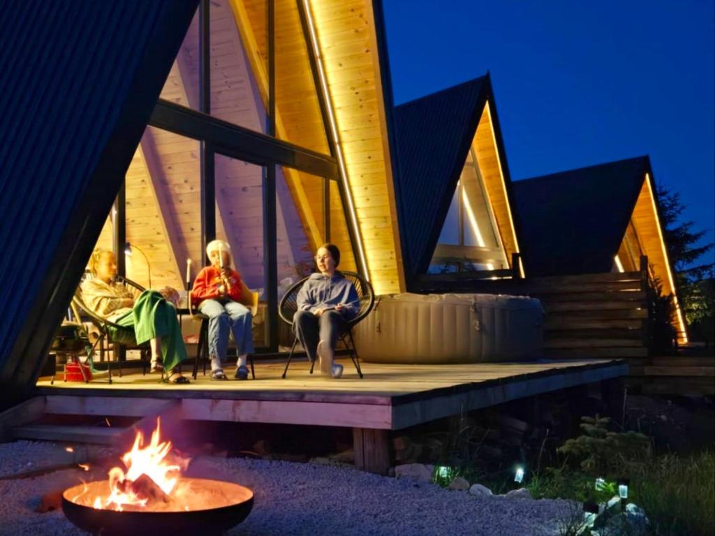 people sitting on the porch of a house with a fire at Hill House Žabljak in Žabljak