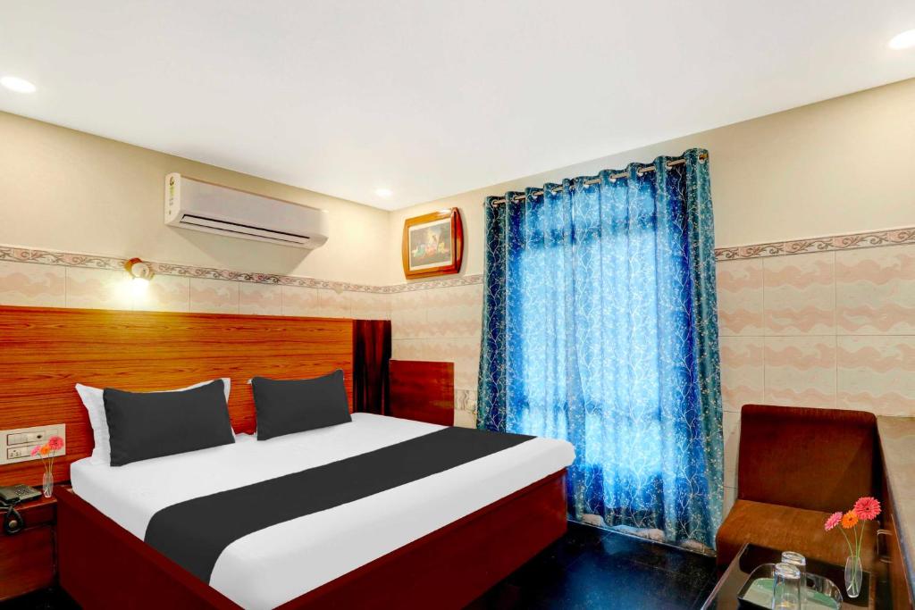 ein Schlafzimmer mit einem Bett und einem Stuhl darin in der Unterkunft Collection O Vijaywada Railway Stadium in Vijayawāda