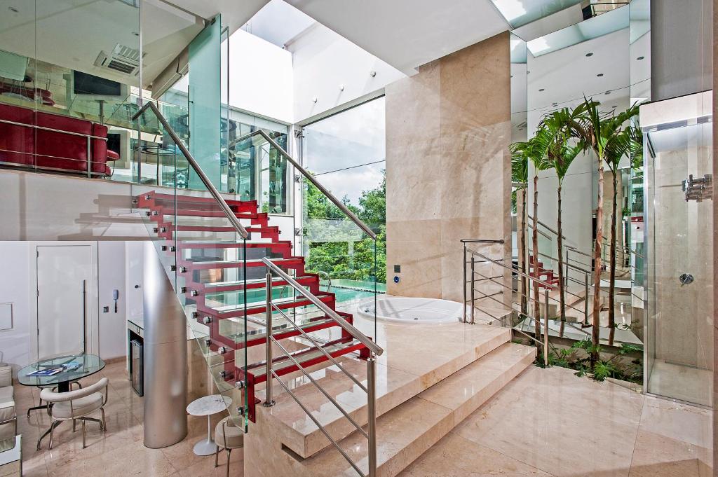 un escalier dans une maison aux parois de verre dans l'établissement Motel Acqua (Adult Only), à Curitiba