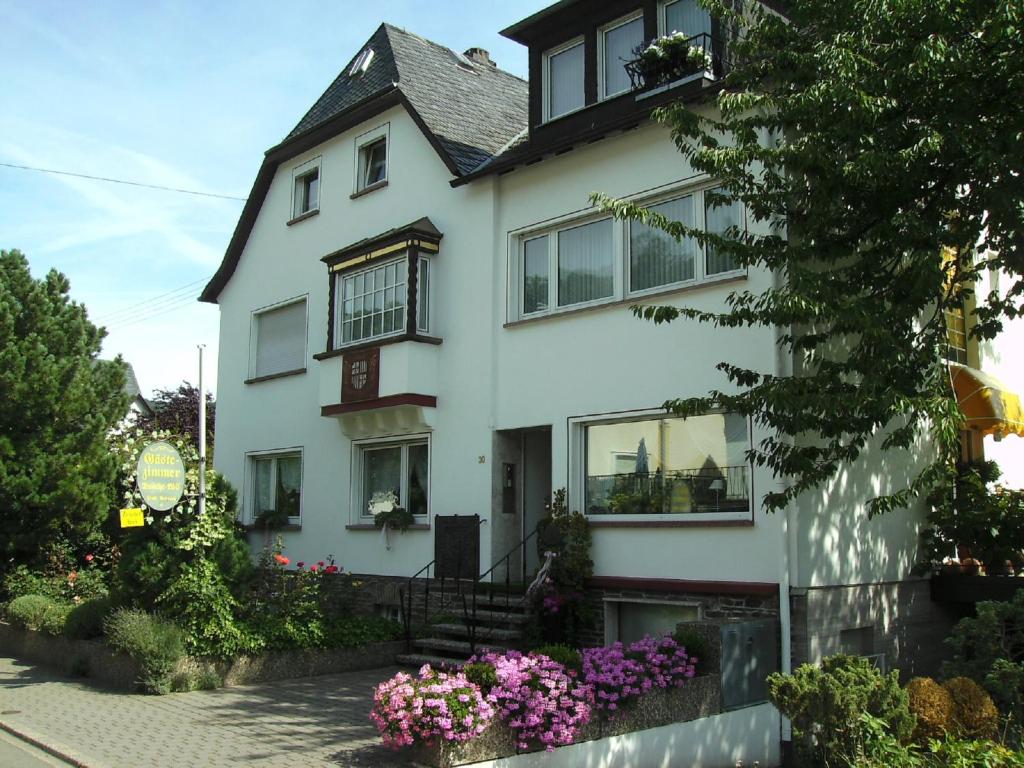 una casa bianca con dei fiori davanti di Haus Marientaler Au a Zell an der Mosel