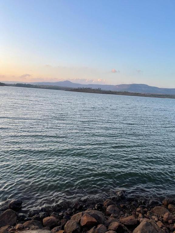a large body of water with rocks on the shore at Bellajooz Lake Resort in Takwa Budrukh