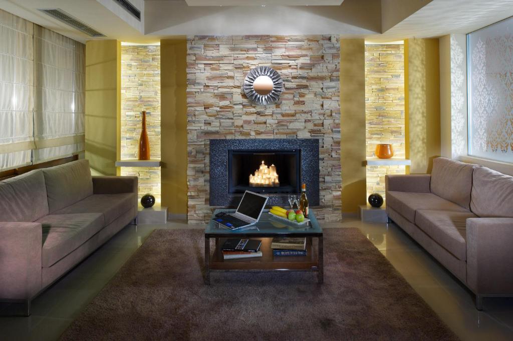 a living room with two couches and a fireplace at Pefka Hotel in Thessaloniki