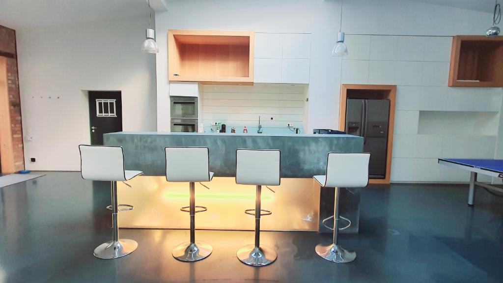 a kitchen with a bar with four chairs in it at Stylisches City Loft mit Terrasse, zentral & eventgeeignet in Mannheim