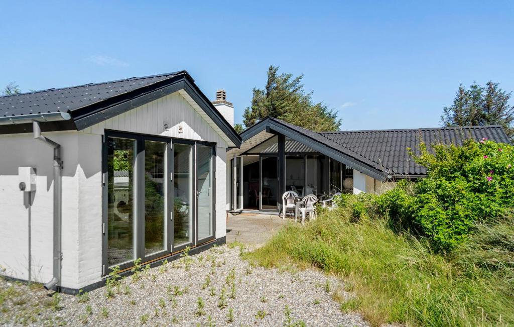 une maison avec des portes coulissantes en verre sur le côté dans l'établissement Amazing Home In Thisted With Sauna, à Torsted