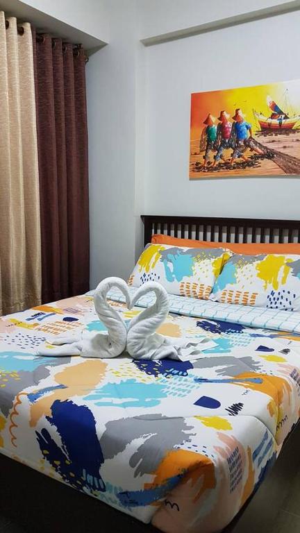 two swans are forming a heart on a bed at Gerbi's Condoplace at Oceanway Residences in Sampong