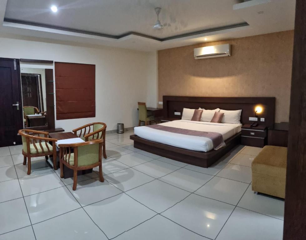 a bedroom with a bed and a table and a desk at Emperorhotel in Jāmb