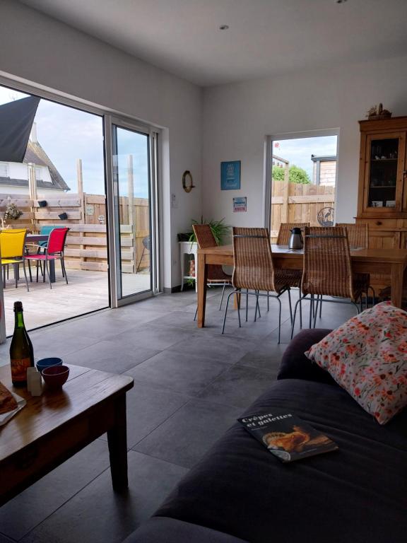 un salon avec un canapé, une table et des chaises dans l'établissement R' DU LARGE Maison spacieuse 2 mn de La Torche, à Penmarcʼh