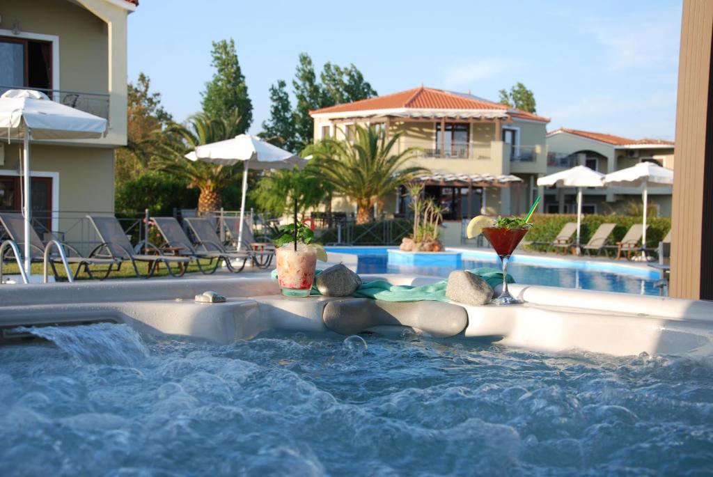 Una donna sdraiata in una piscina in un resort di Imerti Resort Hotel a Skala Kallonis