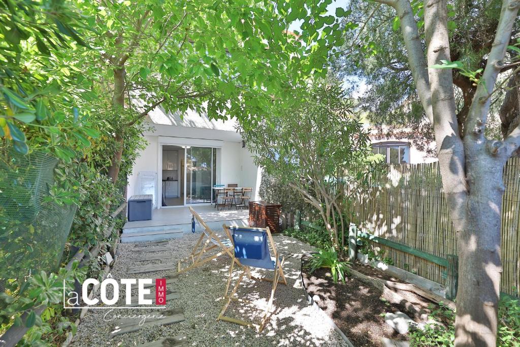 une cour avec des chaises et une clôture dans l'établissement La Cabane bleue, à Sausset-les-Pins