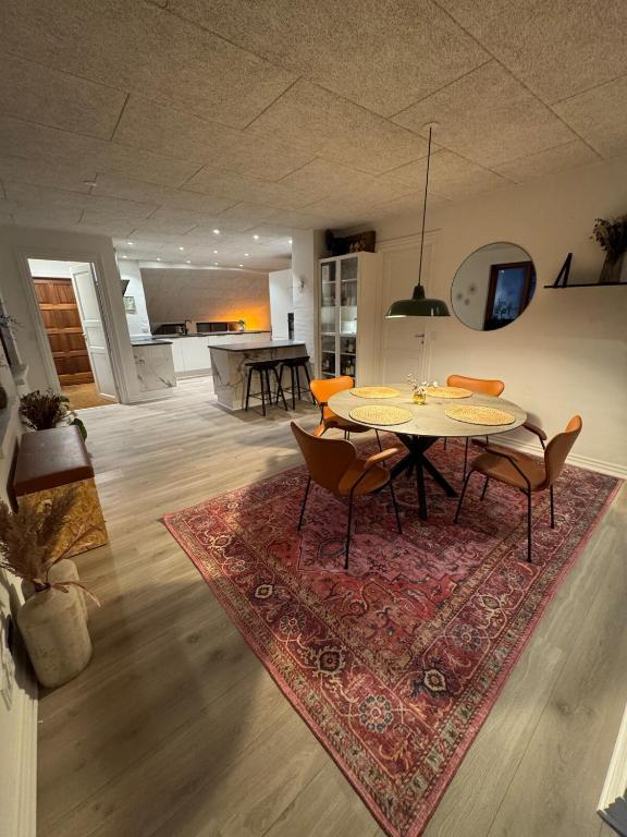 a dining room with a table and chairs on a rug at Villa Centrum in Holstebro