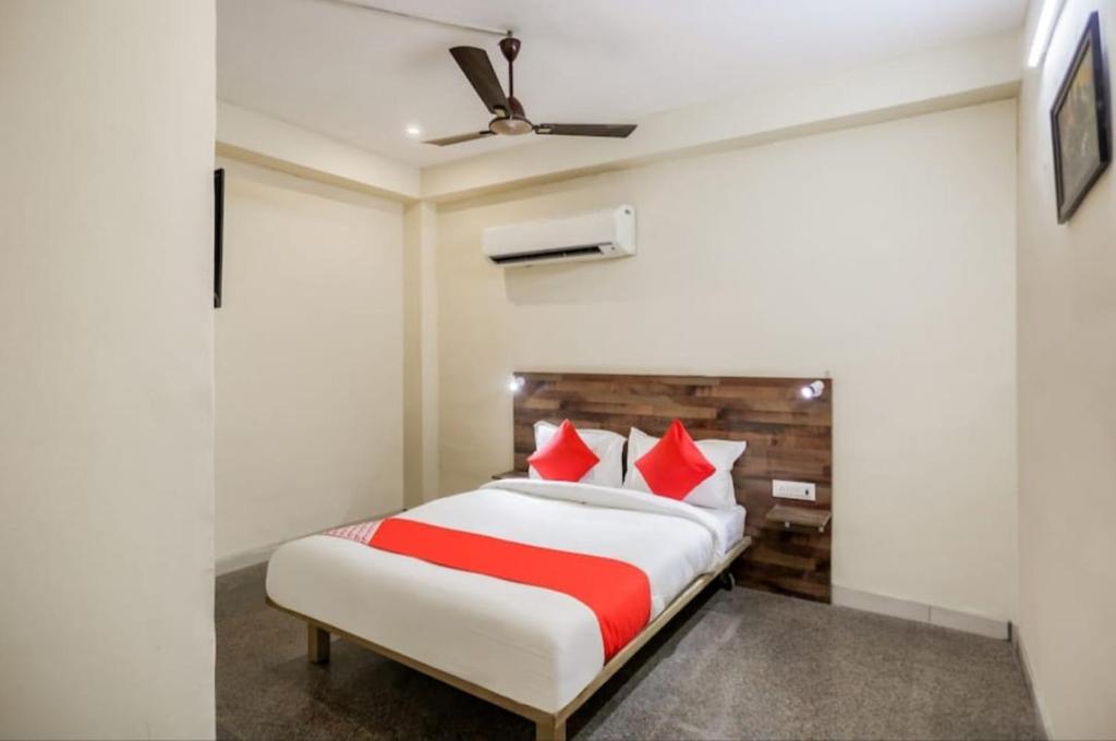 a bedroom with a large bed with red pillows at solstice suites in Faridabad