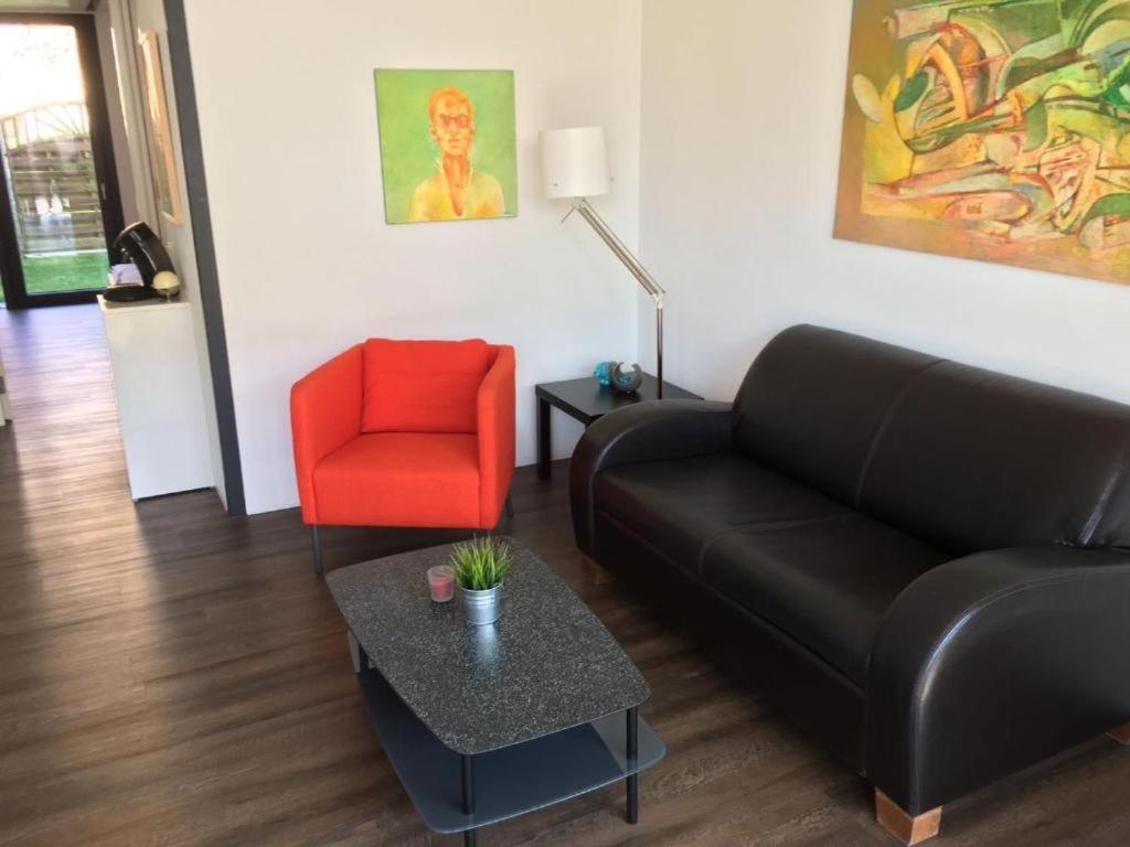 - un salon avec un canapé et un fauteuil rouge dans l'établissement See und Mehr Apartment 2, à Stetten