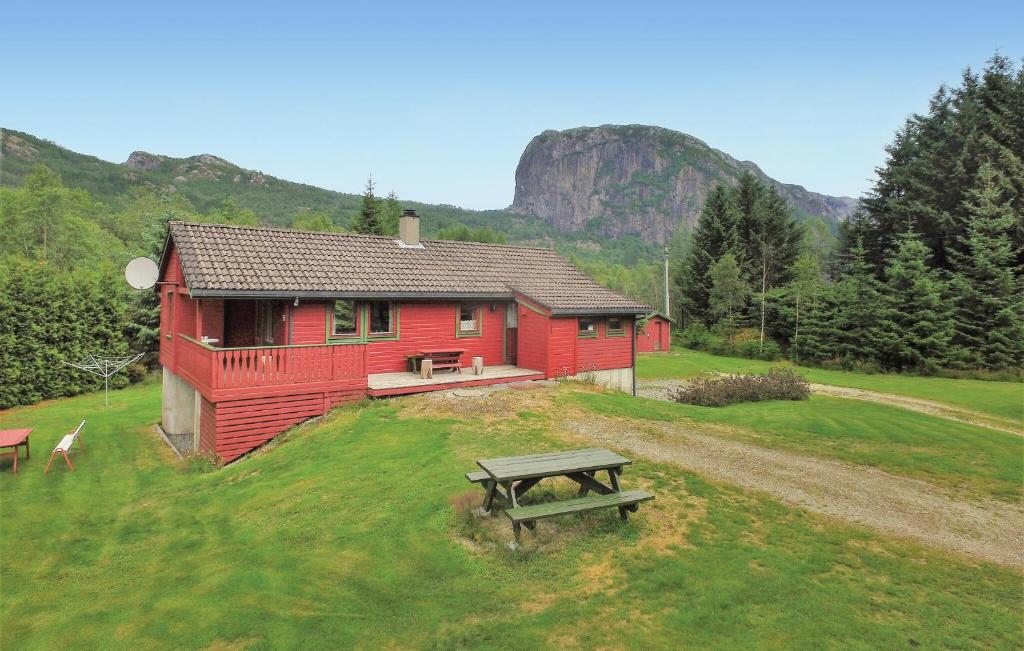 a red house with a picnic table in front of it at 3 Bedroom Gorgeous Home In Vikeså in Vikeså