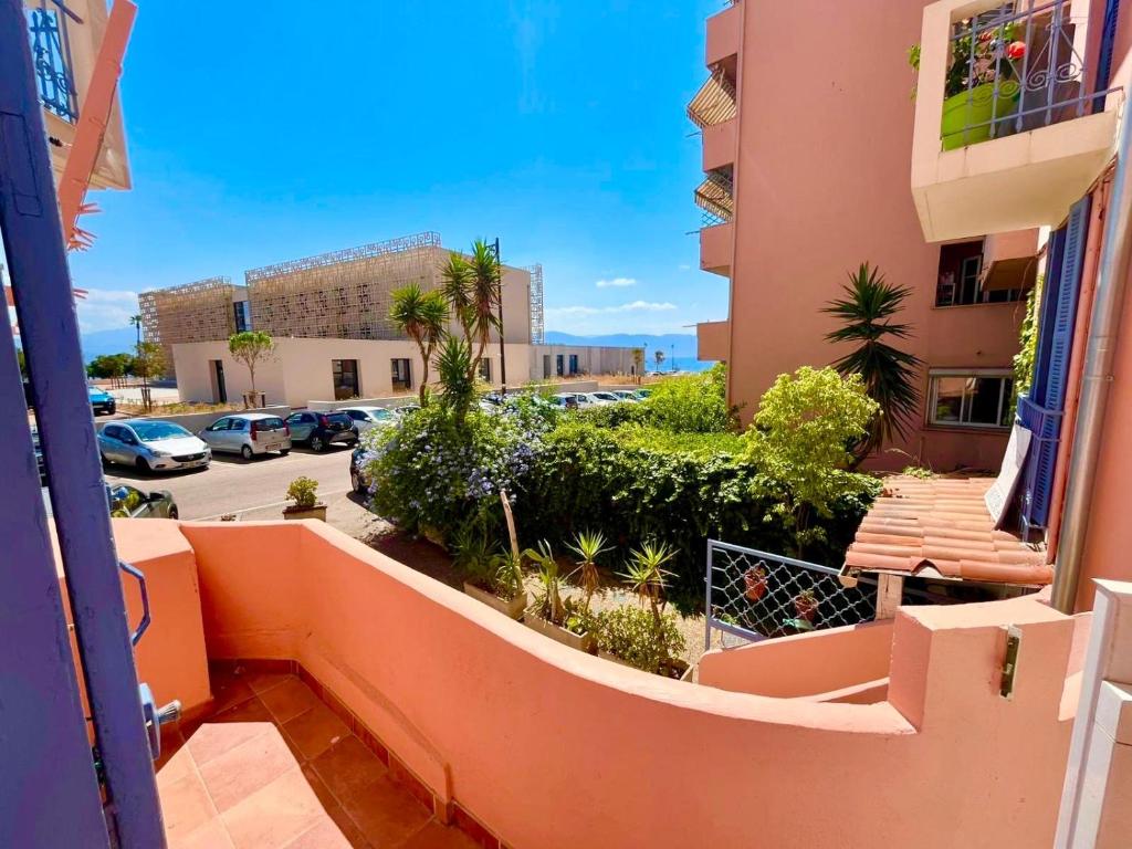 un balcon avec vue sur un parking dans l'établissement Casamea- Famille, Plage 2 min, à Ajaccio