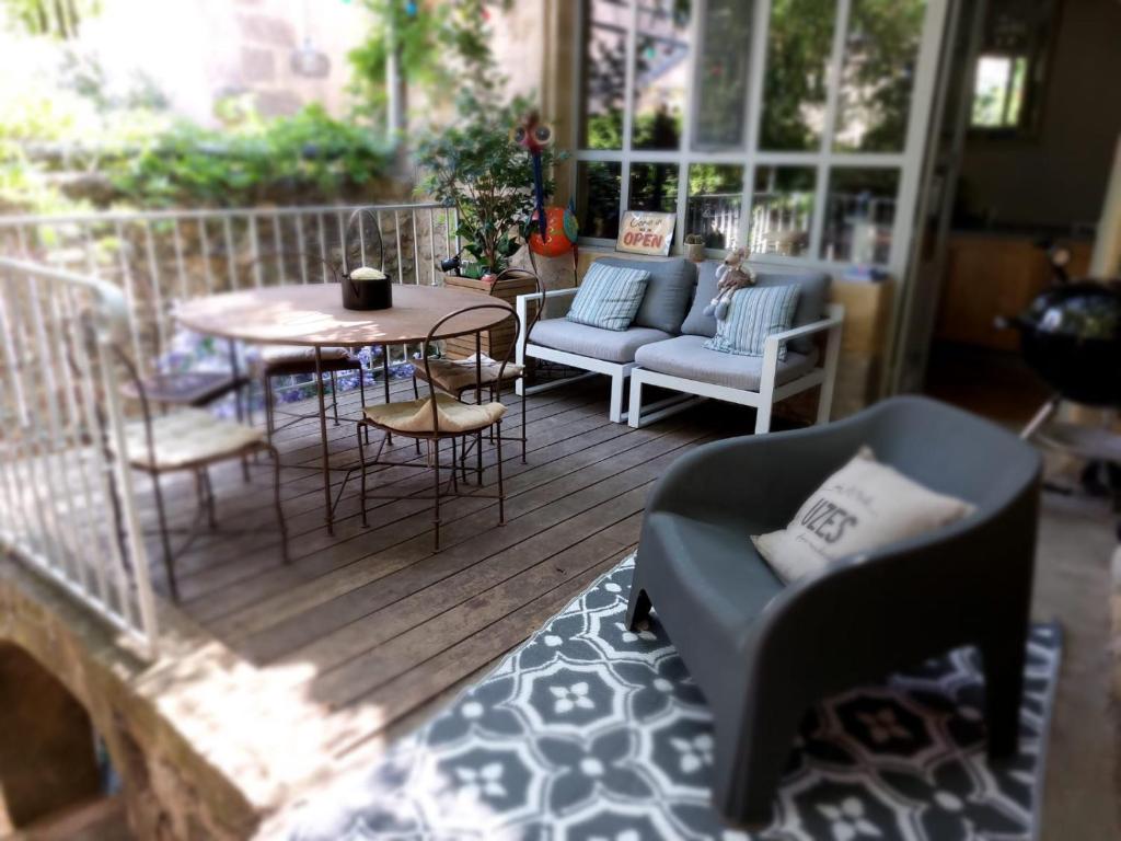 un patio avec une table et des chaises sur une terrasse dans l'établissement UZES CÔTÉ VILLAGE - Chambre d'hôtes, à Fontarèches