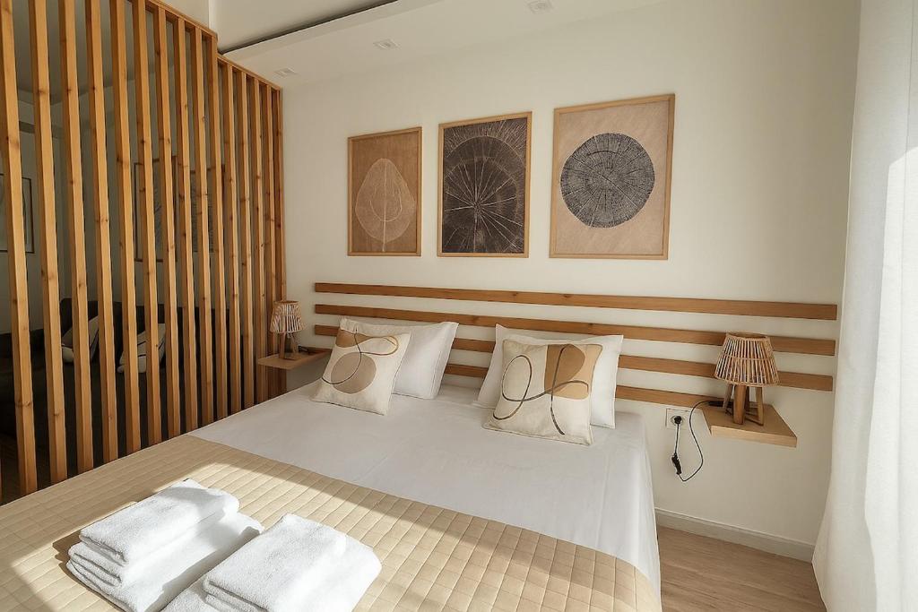 un dormitorio con una cama con sábanas y almohadas blancas en Καλαίσθητο Ηλιόλουστο Studio, en La Canea
