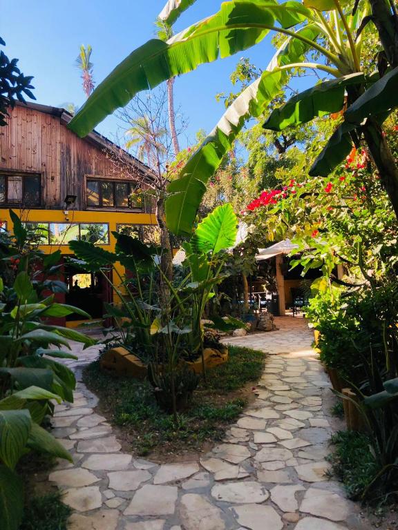a walkway through a garden with plants and a building at Hotel LE BOEUF in Mandriankeniheny