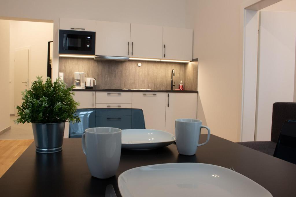 una cocina con una mesa con dos tazas. en Klimt Apartments, en Viena