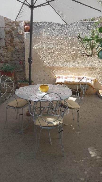 une table et deux chaises avec un parasol dans l'établissement La maison de jeanne, à Vauvert