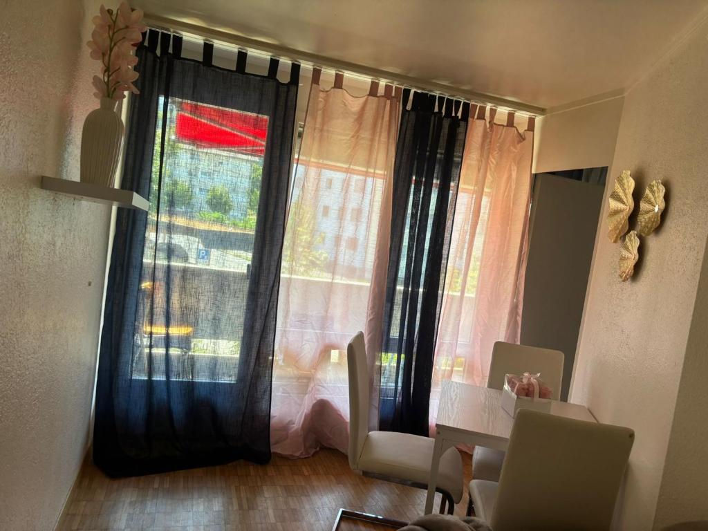 a living room with a window with a table and chairs at Bern str 140 in Ostermundigen
