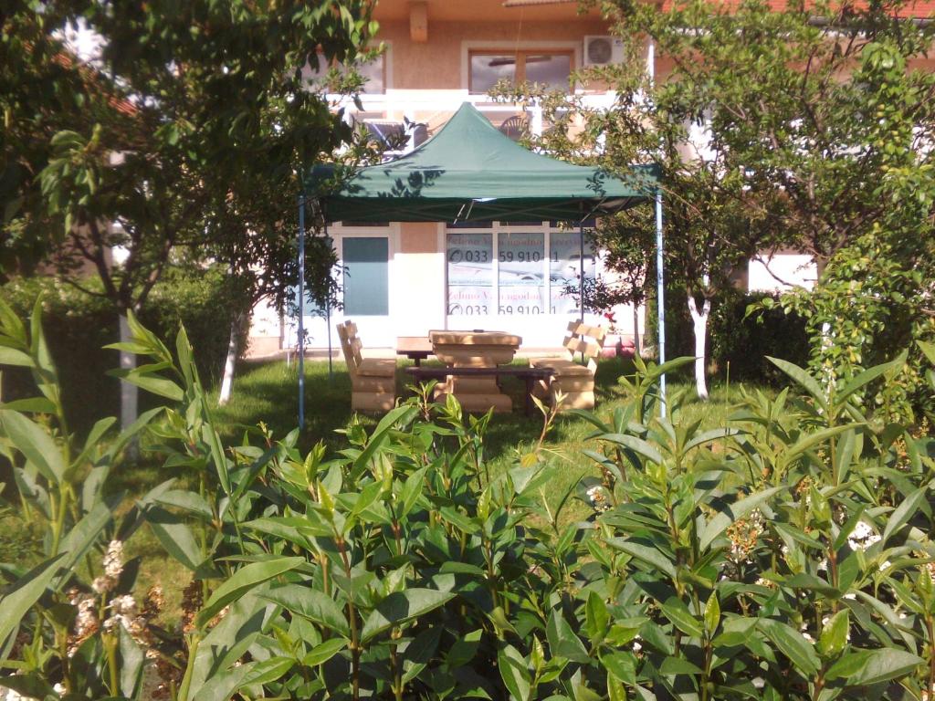 a gazebo with a picnic table in front of a house at Holiday Home Hodo in Sarajevo