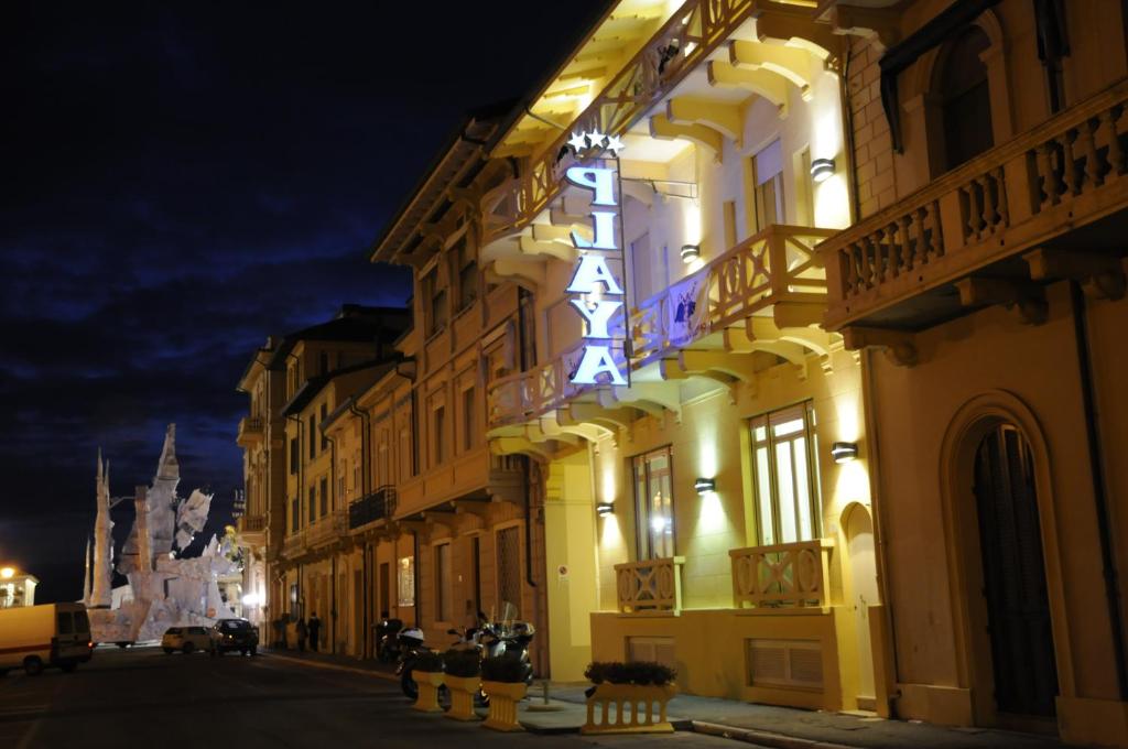 a building with a sign on the side of it at night at Hotel Playa in Viareggio