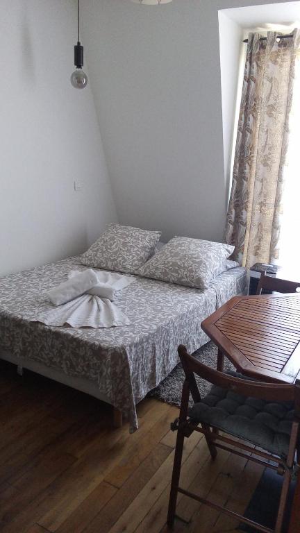 une chambre avec un lit, une table et une chaise dans l'établissement Corazon de Paris, à Paris