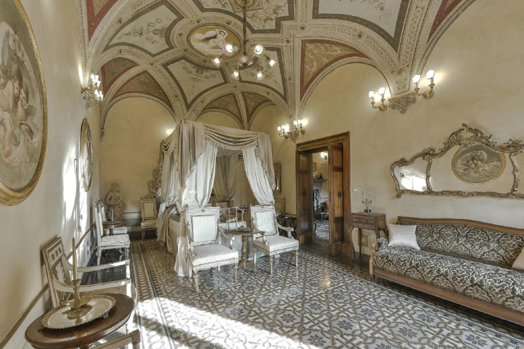 a large room with a couch, chairs, and tables at Residenze d'Epoca Palazzo Coli Bizzarrini in Siena